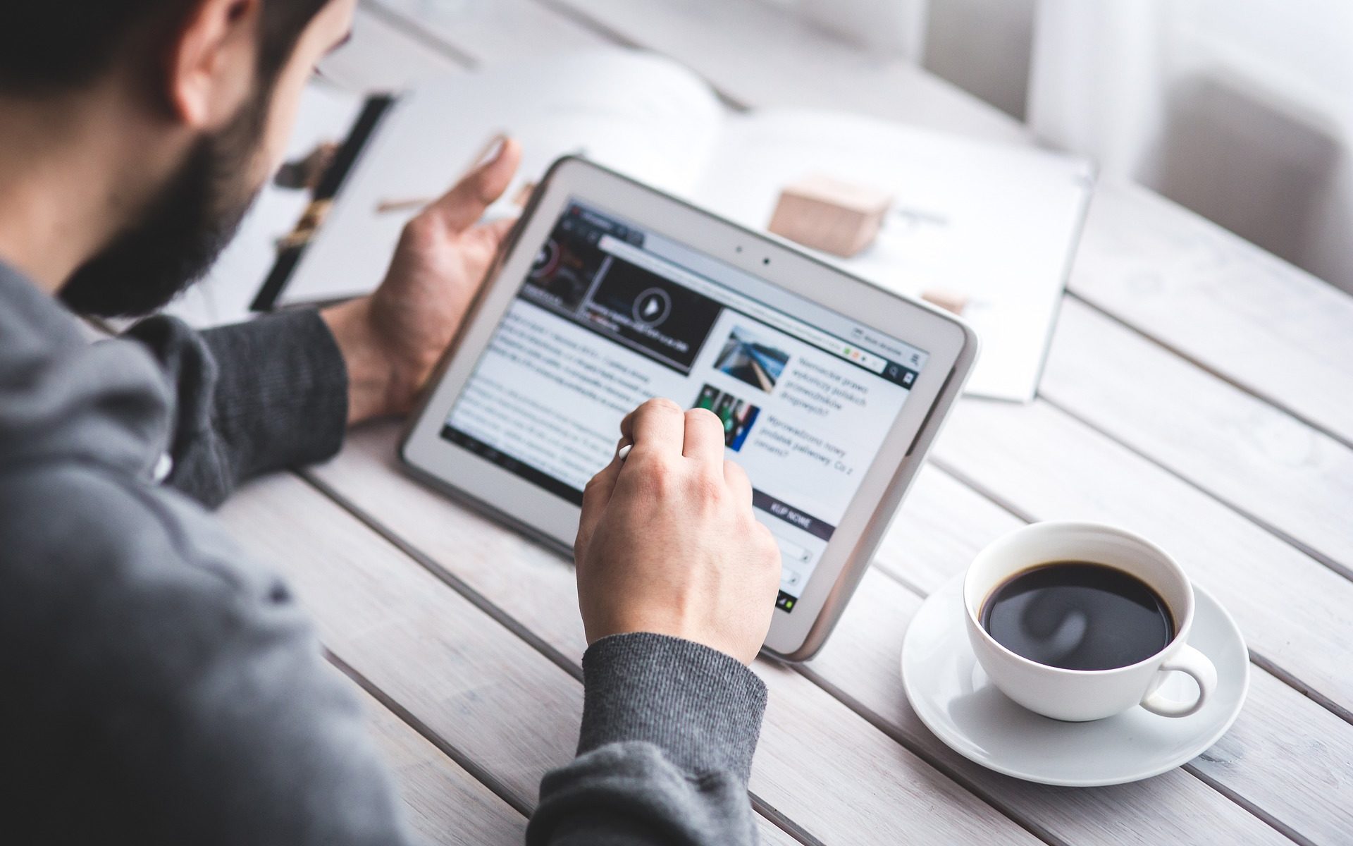 man reading magazine on tablet