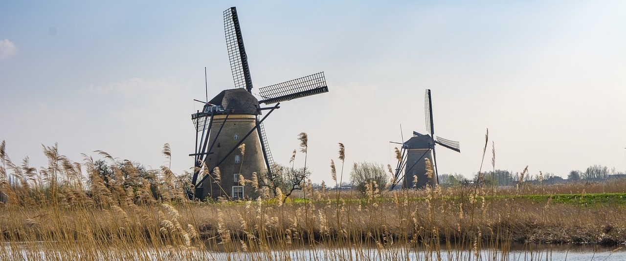 Two Dutch windmills with a stream in the foreground